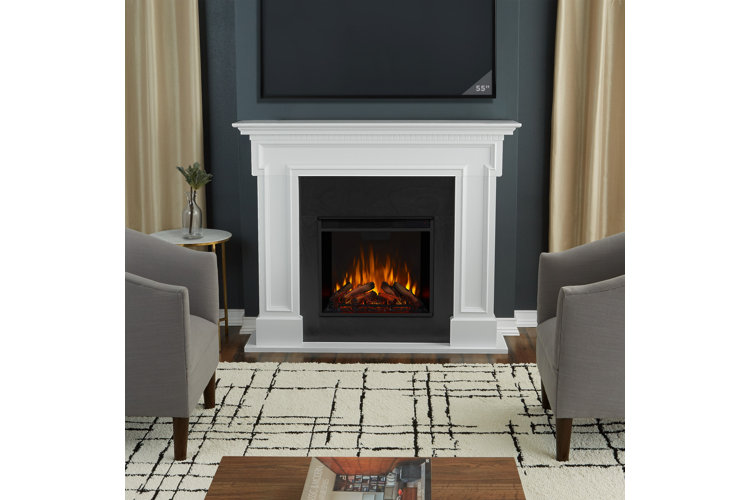 A living room with two gray barrel chairs on either side of a white electric fireplace and beneath a wall-mounted TV.