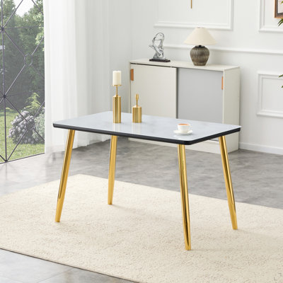Table de salle à manger moderne et minimaliste, pour 4 à 6 personnes. Comptoir en verre trempé + panneau de fibres à densité moyenne inférieur, texture imitation marbre, pieds fuselés en métal doré. Convient aux restaurants minimalistes.