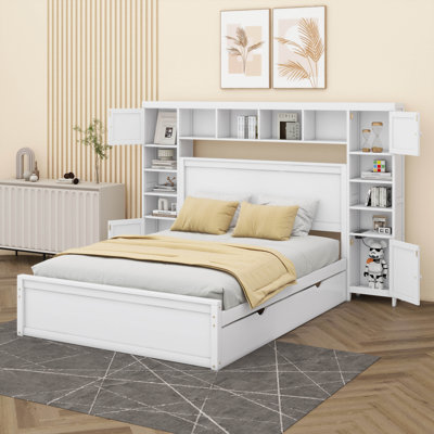 Un lit double en bois avec armoire intégrée, tablette et prises électriques, accompagné d'un lit gigogne simple.