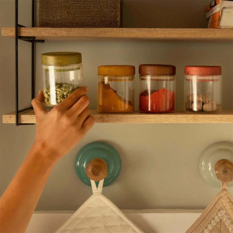 Ensemble de pots en verre élégants et fonctionnels avec couvercles en bois, parfaits pour organiser les épices et les condiments dans les cuisines modernes.