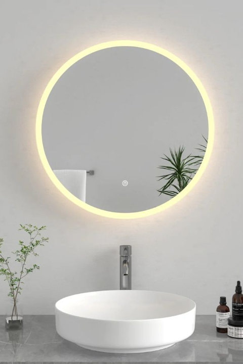 Round bathroom wall mirror with integrated LED backlight and touch-button control mounted above a modern vessel sink and faucet.