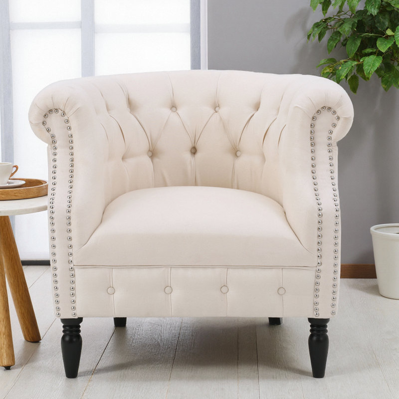 Élégant fauteuil club en tissu beige Akira avec dossier capitonné et accoudoirs cloutés, Tissu beige