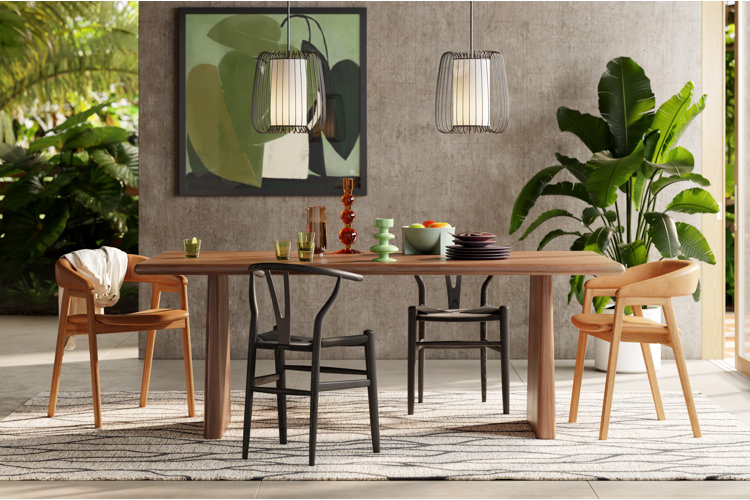 A semi indoor outdoor dining space with concrete walls and floor natural wood dining table set and biophilic design and plants