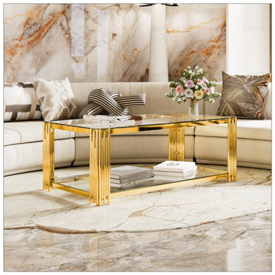 Table basse moderne en verre transparent avec structure asymétrique en métal et tablette inférieure, idéale pour les espaces de vie contemporains.