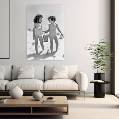 Années 1930, deux filles souriantes, sœurs, amis, tenant par la main, seau à sable et pelle, marchant sur une dune de sable, rétro, rétro, plage, art mural