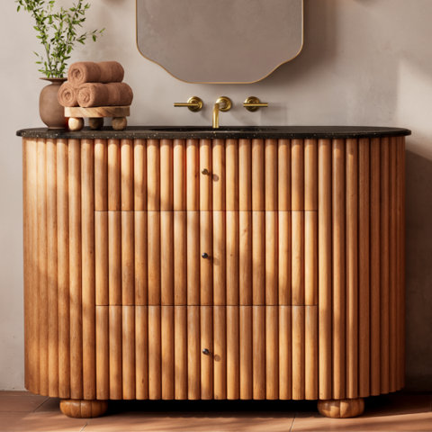 Bathroom vanity with reeded drawer fronts.