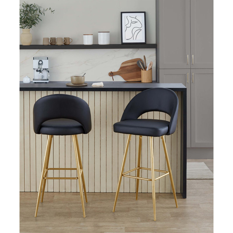 Ensemble de 2 tabourets de bar à hauteur fixe avec structure en métal doré, siège en similicuir noir, repose-pieds carré et siège intérieur ergonomique.