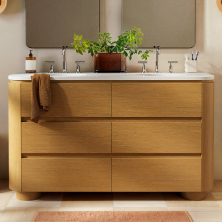 Bathroom vanity with a white sink and wood cabinet.