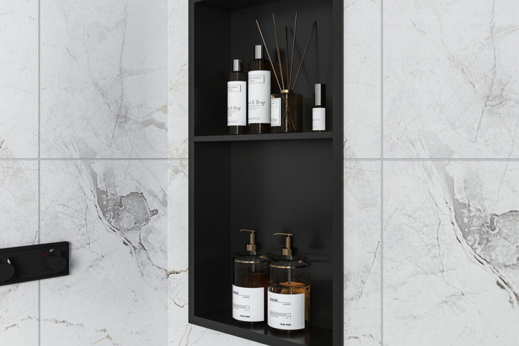 white marble shower enclosure with a black shower niche used to store shampoo and conditioner bottles.