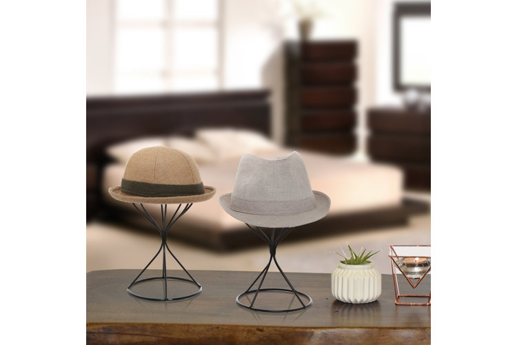 collection of hat display stands and hats on a table