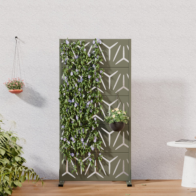 Olive green metal privacy screen with a laser-cut geometric pattern, shown freestanding with climbing plants.