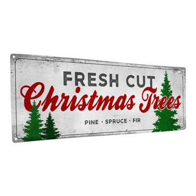 Plaque noire en métal avec arbres de Noël fraîchement coupés