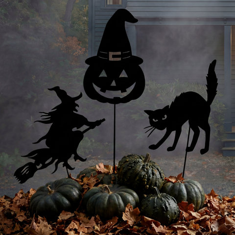 Piquets de jardin d'Halloween représentant une sorcière volante, une citrouille et un chat noir parmi des citrouilles