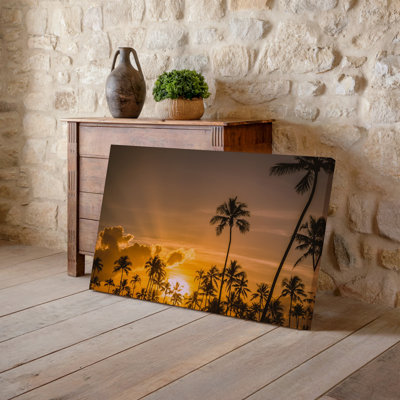 Canvas A Breathtaking Tropical Sunset Scene Featuring Silhouetted Palm Trees Against Wall Art A Vibrant Orange Sky The Sun Partially Canvas Wall Art