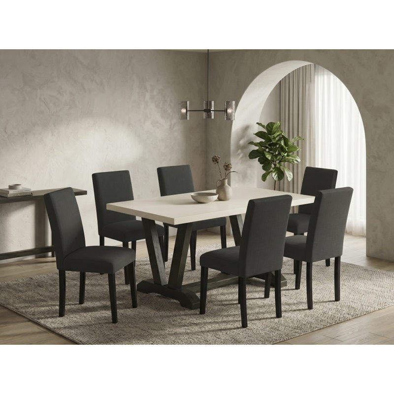 L'ensemble de 7 pièces de salle à manger se compose d'une table de salle à manger rectangulaire Jacobean patinée avec des pieds en V et de 6 chaises rembourrées en tissu de lin noir, finition noire brossée