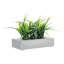 Faux herbes vertes dans une boîte en béton gris