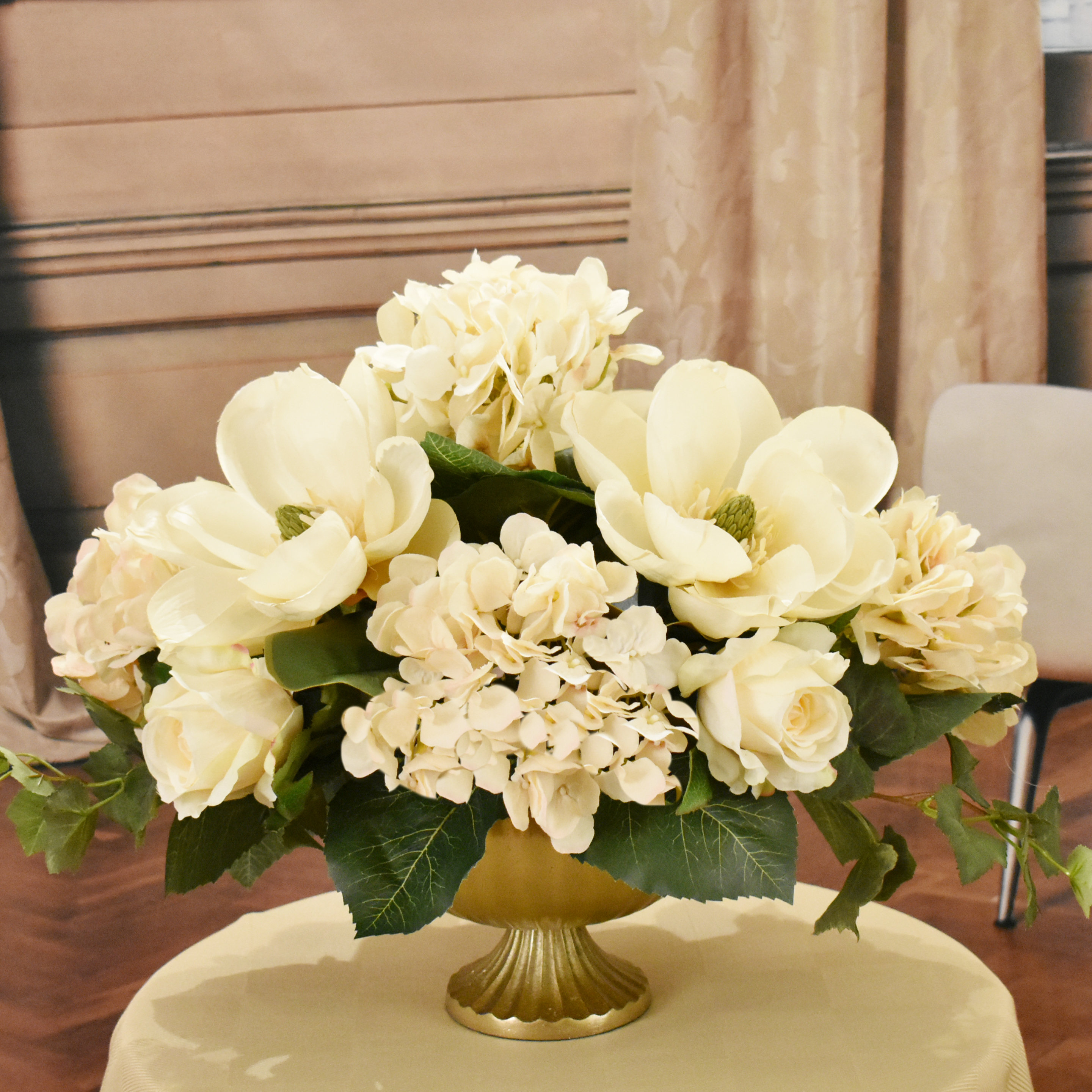 Cream Magnolia and Hydrangea Silk floral Centerpiecein Embossed Oval Vase.