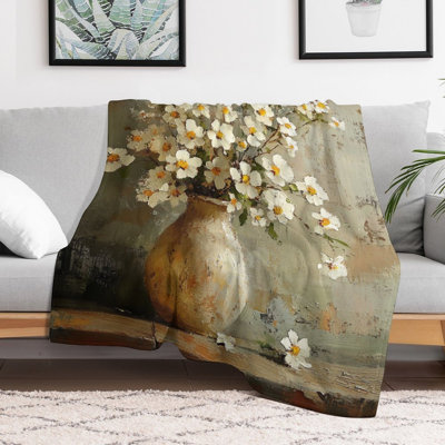Fleurs blanches dans un vase rustique sur une luxueuse couverture en flanelle de bois, couverture douce et chaude pour le canapé-lit du salon
