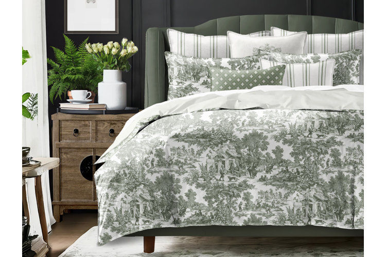 bed in french country style bedroom with green and ivory toilet pattern bedding