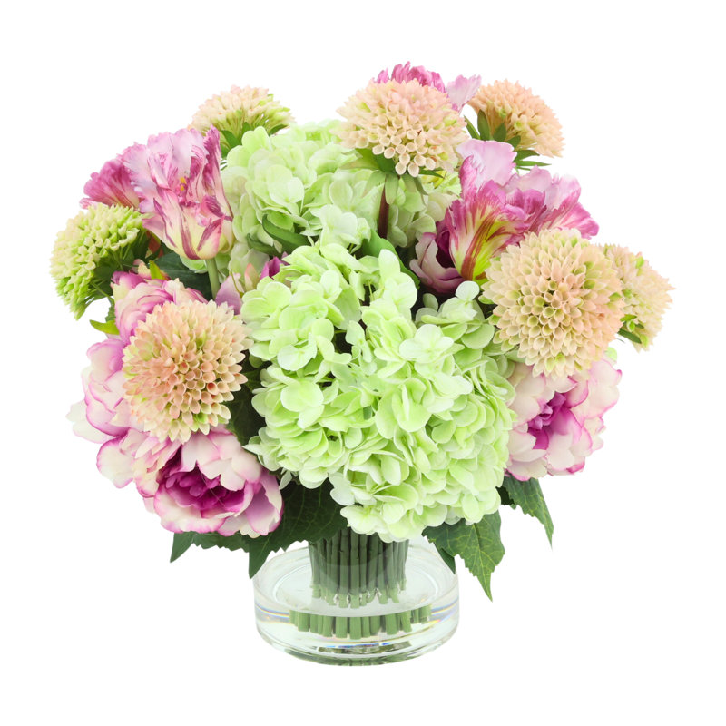 Hortensias, pivoines et tulipes disposés dans un vase en verre