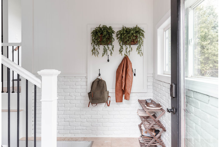 small mudroom with a collapsible shoe rack and mounted wall hooks
