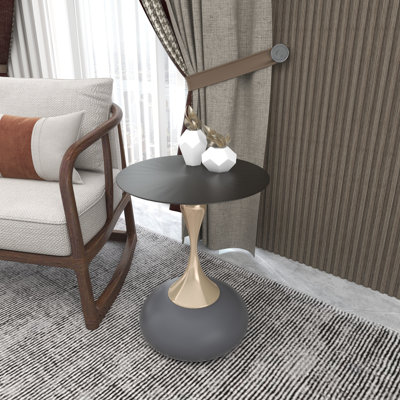 Table d'appoint ronde Damya, table de chevet en acier inoxydable noir avec plateau métallique brossé et pied central incurvé sculptural, finition thermolaquée pour salon, bureau et usage quotidien