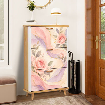 Meuble à chaussures à 3 tiroirs rabattables, orné de délicates roses roses, de vagues pastel et de détails dorés. Ce meuble de rangement étroit et discret en bois est idéal pour une entrée, un corridor, un hall d'entrée, un dressing ou un petit appartement.