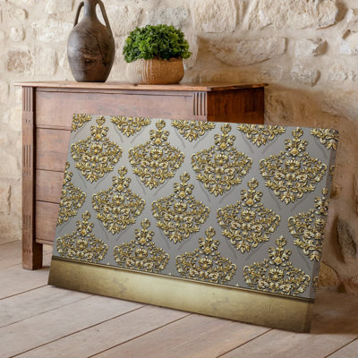 La toile crée un design de papier peint élégant avec un motif damassé complexe en or chatoyant contre un taupe doux