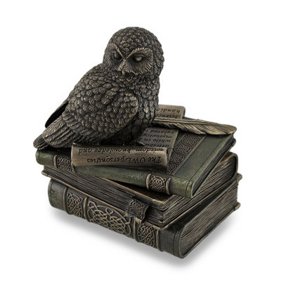 Statue de hibou perché sur une pile de livres