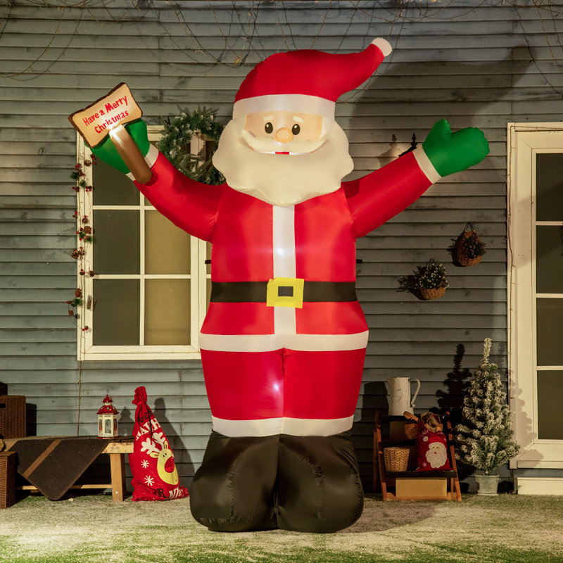Père Noël de Noël tient un signe de bénédiction gonflable