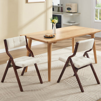 Chaise pliante au design élégant avec structure en bois massif et dossier et siège rembourrés capitonnés