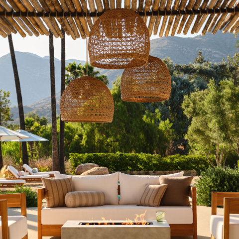 Outdoor living space with wicker pendant lights and seating.