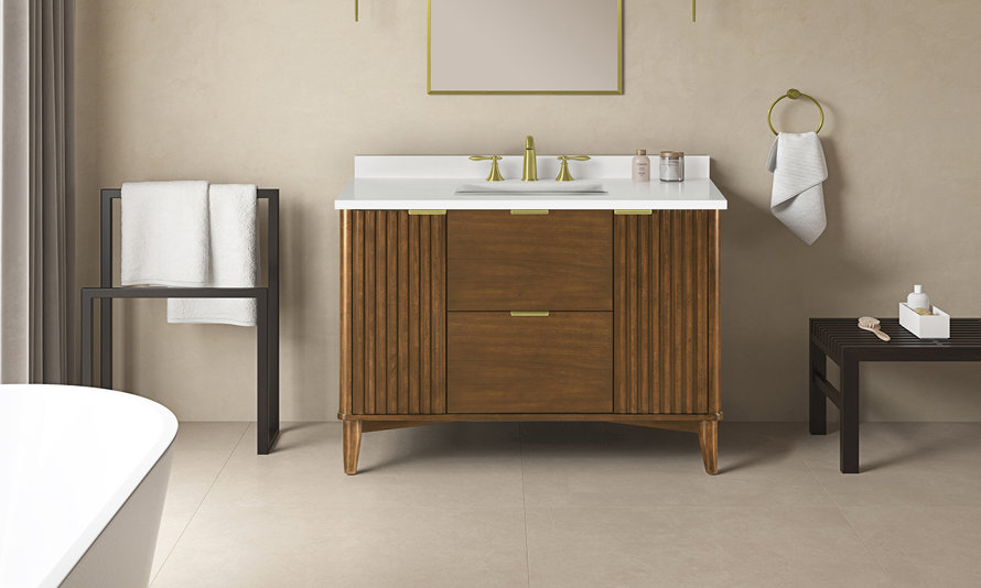 Mid-century modern single bathroom vanity in medium walnut with fluted door panels, brass hardware, and a white countertop in a neutral-toned bathroom.