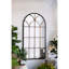 Miroir arqué noir et or de 34 po x 65,5 po de long, complément aux éléments décoratifs du salon dans la chambre à coucher
