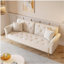 Luxueux canapé-lit en velours beige avec garniture cloutée et coussin décoratif assorti pour une vie élégante