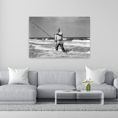 1950s OLDER MAN STANDING IN SURF IN WADERS HOLDING FISH IN ONE HAND FISHING POLE IN OTHER 1 Piece Wrapped Canvas Wall Art