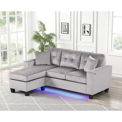 Canapé modulaire réversible avec lumière DEL, port USB, coussins capitonnés et garniture cloutée pour les espaces de vie modernes.