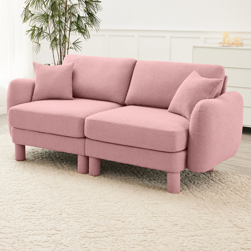 Canapé 2 places rose en tissu bouclé avec pieds cylindriques et en forme de coquillage, offrant une assise confortable et unique conçue pour un confort de détente dans la chambre.