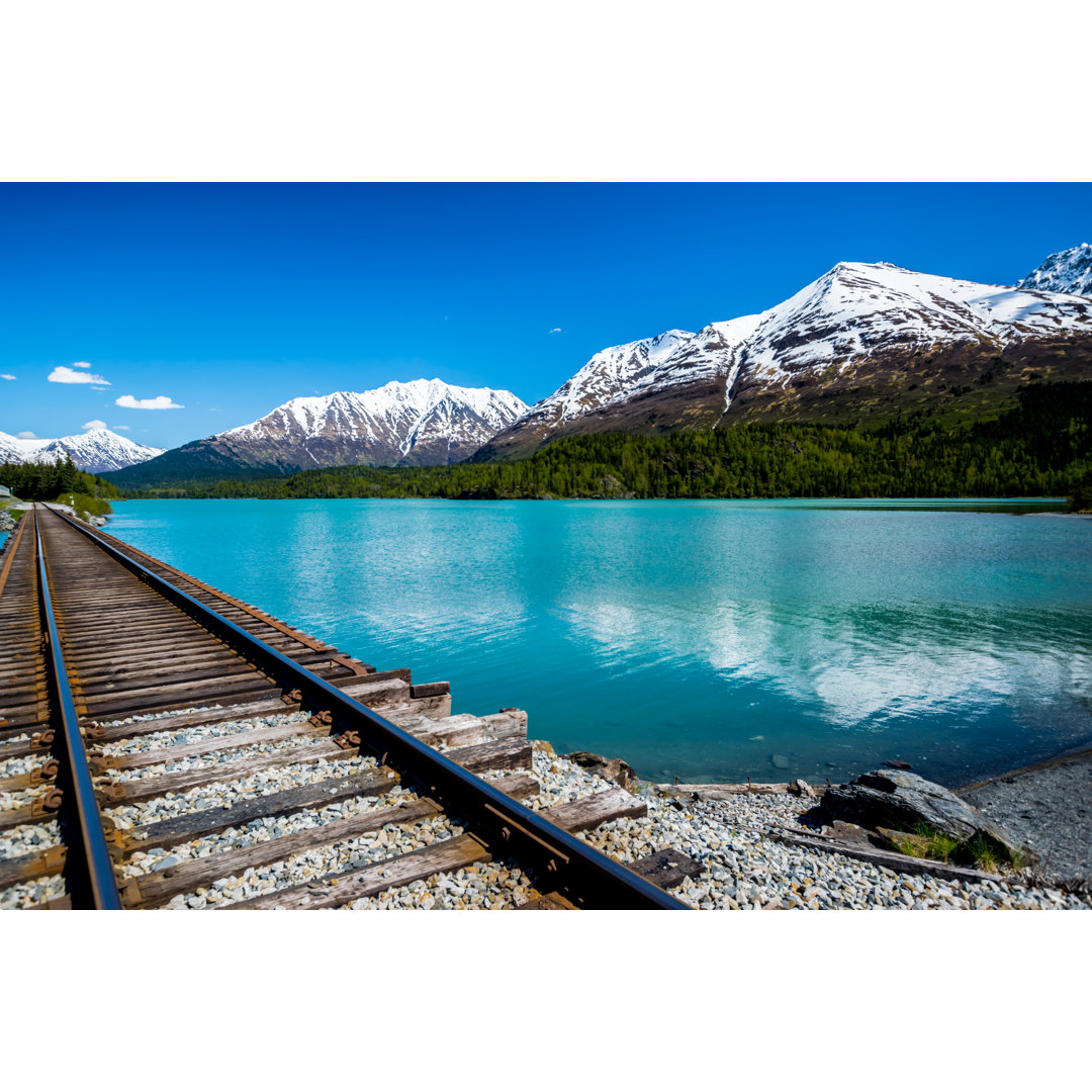 Bahnstrecke mit See und Bergkette