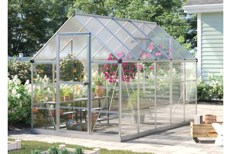 stone patio with a greenhouse with sheer panels, shelving, and hanging flower baskets