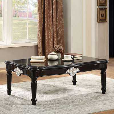 Table basse noire avec pieds tournés.