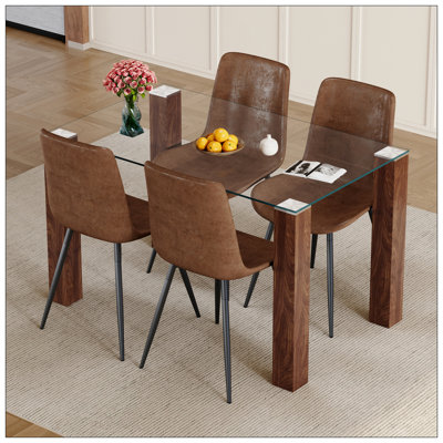 Ensemble de table et de chaises.Une table de salle à manger en verre trempé transparent avec pieds en bois aggloméré à grain de bois.