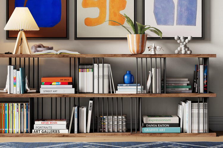 metal-and-wood bookcase with books, magazines, a table lamp, and a potted houseplant