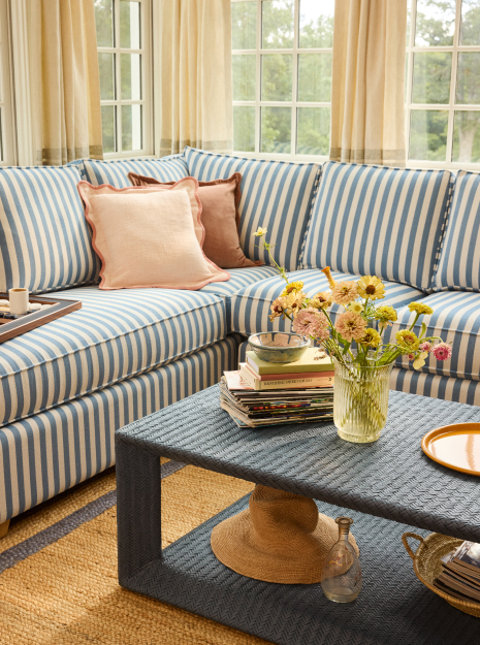 Living room interior with blue striped sofa, patterned coffee table, and natural light.