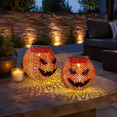 A 2 Pcs set of portable waterproof Metal Halloween solar lanterns uses LED lighting in a hanging Jack O Lantern Pumpkin Design for backyards, gardens, porches, or trees. For outdoor use.