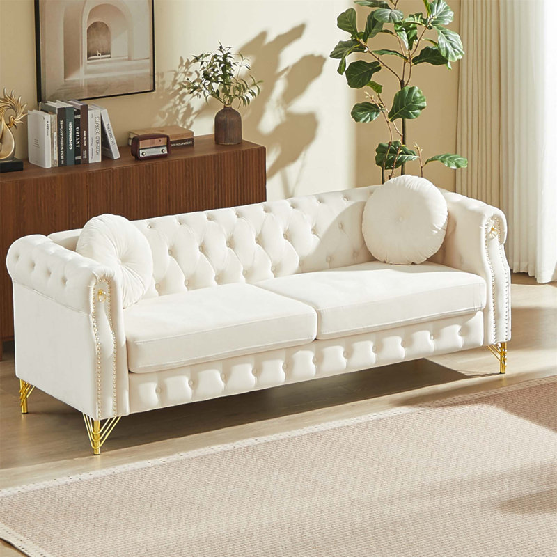 Luxueux canapé Chesterfield en velours de 82 pouces avec des clous en cuivre, des boutons capitonnés et des pieds en métal, y compris deux coussins ronds pour plus de confort.