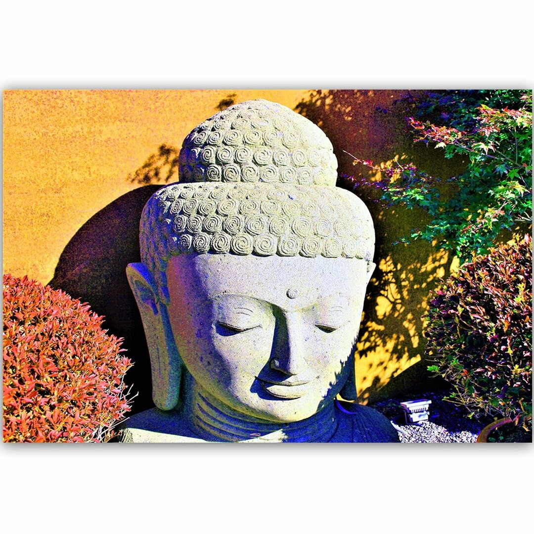 Leinwandbild Kopf des Buddha unter Pflanzen 1