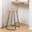 Tabouret de bar et de comptoir Geonna en bois massif, style selle, avec repose-pieds-366021819-343382047