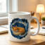 A Ceramic Coffee Mug Featuring a Logo of a Fox Resting in a Nest, Perfect for Enjoying Tea, Milk, Or Water.