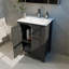 Une armoire de salle de bain noire de 24 pouces, jumelée à un lavabo en céramique blanche, présente un design moderne et est faite de matériaux imperméables et durables.